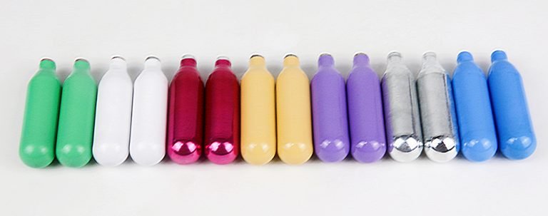 Various cream charger brands lined up on kitchen counter